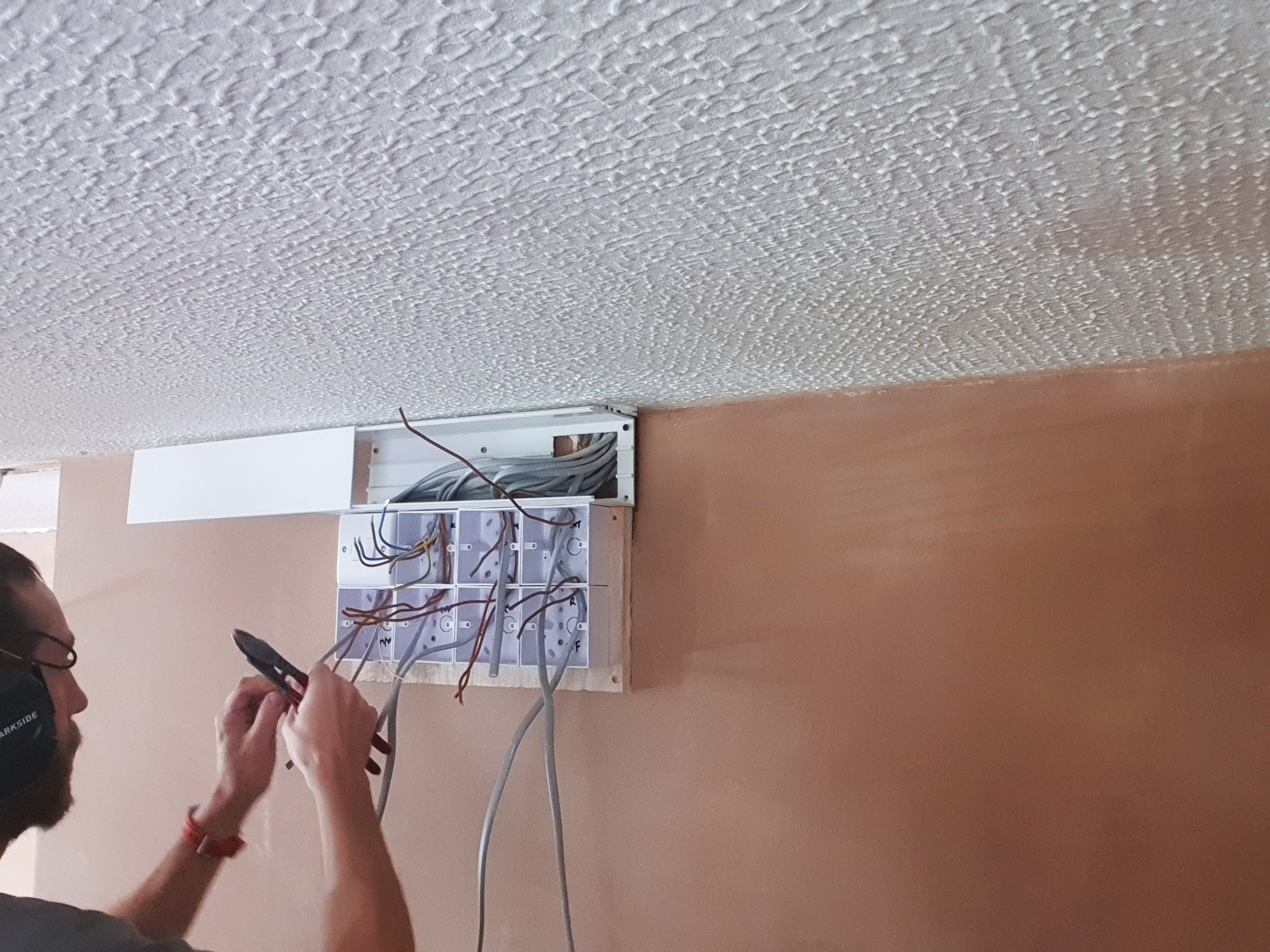 Electrician rewiring a consumer unit in North London